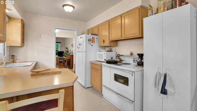 kitchen with white appliances, a sink, light countertops, and light brown cabinets