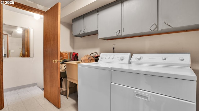 laundry room with cabinet space, washer and dryer, and light flooring