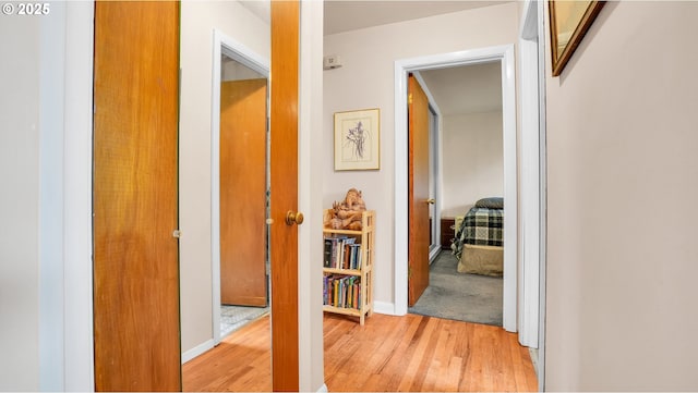 hall with light wood finished floors and baseboards