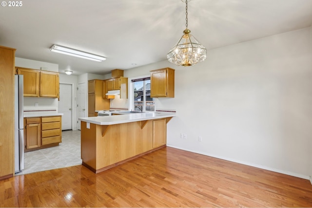 33333 Adam Ct, Scappoose, OR 97056 - kitchen featuring a peninsula, white range, freestanding refrigerator, light wood finished floors, and a chandelier