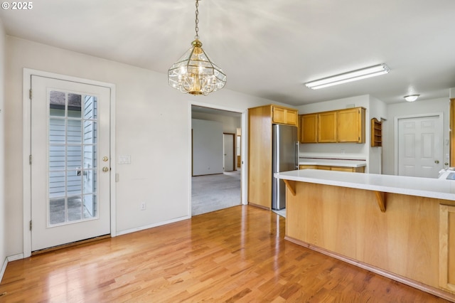 33333 Adam Ct, Scappoose, OR 97056 - kitchen featuring stainless steel refrigerator, light countertops, a chandelier, and a breakfast bar