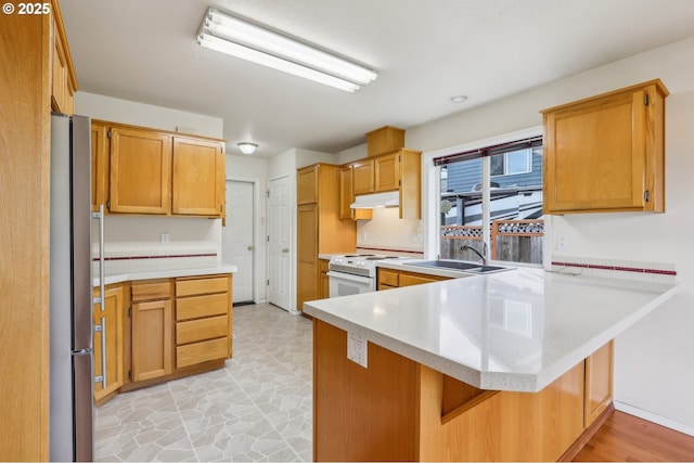 33333 Adam Ct, Scappoose, OR 97056 - kitchen featuring electric stove, freestanding refrigerator, a peninsula, a sink, and under cabinet range hood