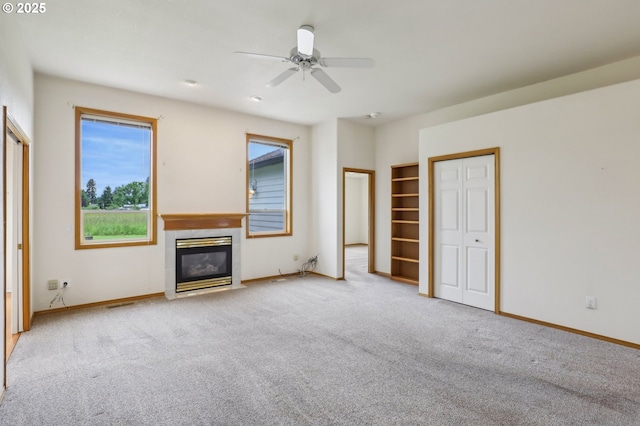 33333 Adam Ct, Scappoose, OR 97056 - unfurnished living room featuring a tile fireplace, carpet floors, a ceiling fan, and baseboards