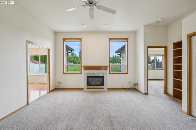 33333 Adam Ct, Scappoose, OR 97056 - unfurnished living room with carpet flooring, a tiled fireplace, baseboards, and a ceiling fan