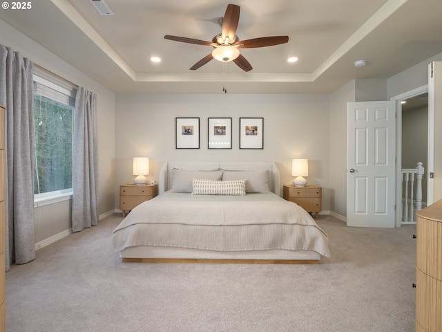 bedroom with visible vents, baseboards, a tray ceiling, light carpet, and recessed lighting