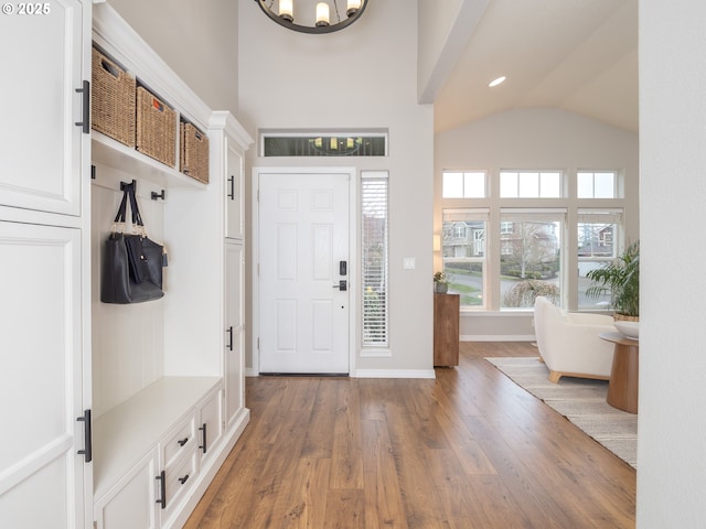 mudroom with high vaulted ceiling, recessed lighting, wood-type flooring, baseboards, and a chandelier