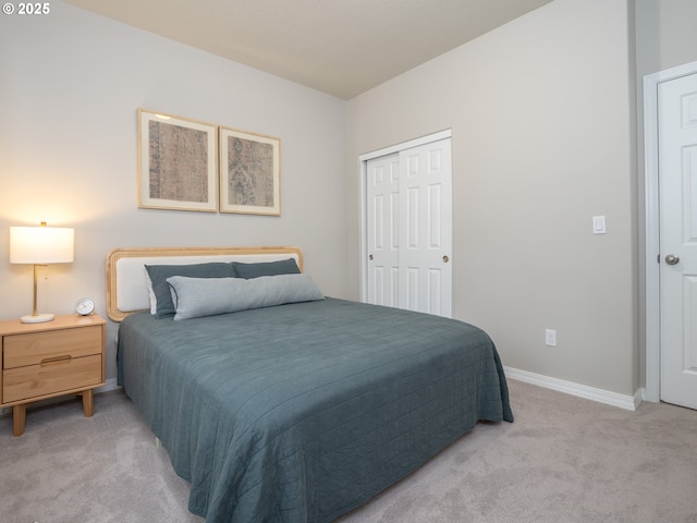 bedroom with baseboards, a closet, and light carpet