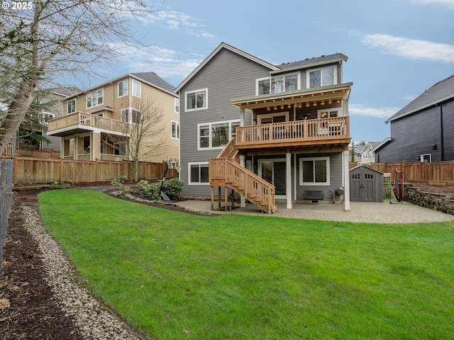 rear view of house with stairway, fence, an outdoor structure, a storage unit, and a patio area