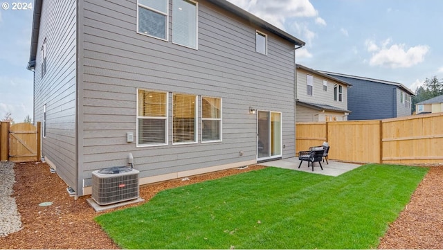 back of property featuring a lawn, central air condition unit, and a patio