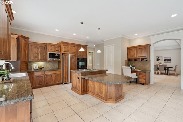 1508 NW 151st St, Vancouver, WA 98685 - kitchen featuring built in appliances, a center island, light tile patterned floors, decorative backsplash, and arched walkways