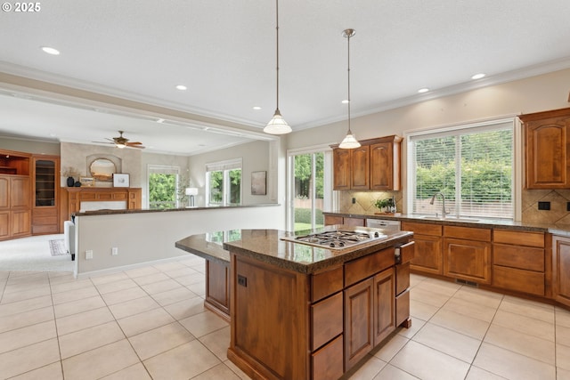1508 NW 151st St, Vancouver, WA 98685 - kitchen with stainless steel gas stovetop, brown cabinets, a kitchen island, backsplash, and light tile patterned floors