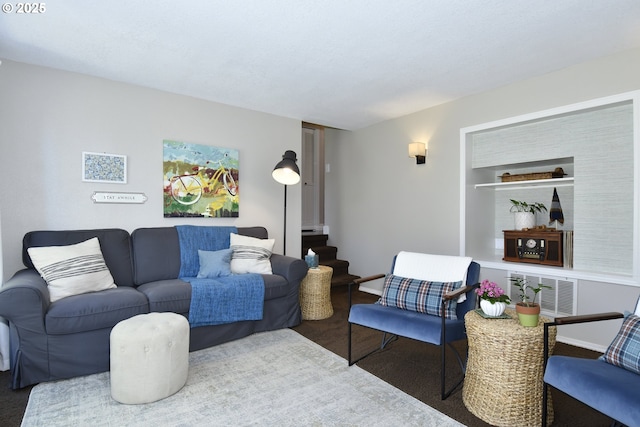 living room featuring built in shelves, carpet flooring, and visible vents