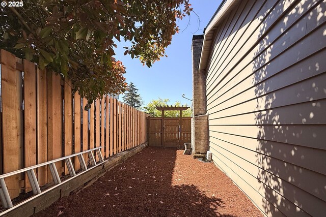 view of side of property with a gate and fence