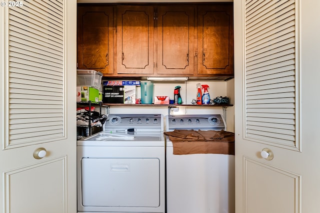 washroom with cabinet space and washer and clothes dryer