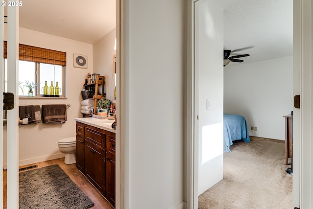 bathroom with a ceiling fan, visible vents, vanity, and toilet