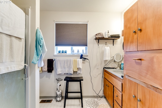 full bathroom with vanity, an enclosed shower, visible vents, and tile patterned floors