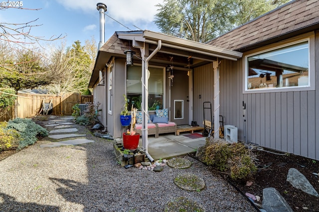 rear view of property featuring roof with shingles, a patio area, and fence