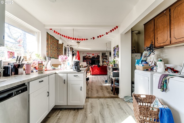 kitchen featuring light wood finished floors, light countertops, washing machine and dryer, open floor plan, and dishwasher