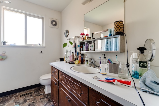 bathroom featuring toilet, baseboards, visible vents, and vanity