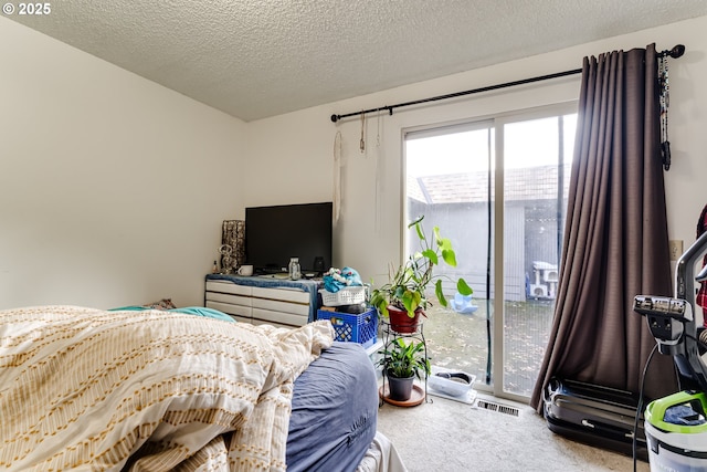 bedroom with carpet, visible vents, and a textured ceiling