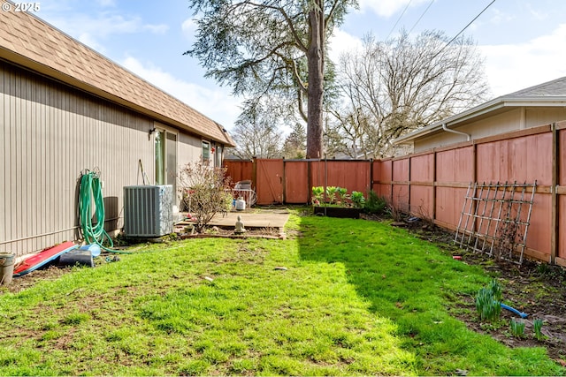 view of yard with central AC unit and a fenced backyard