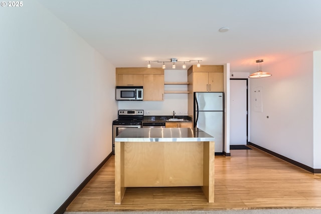 kitchen with stainless steel appliances, light wood-style floors, light brown cabinets, and a sink