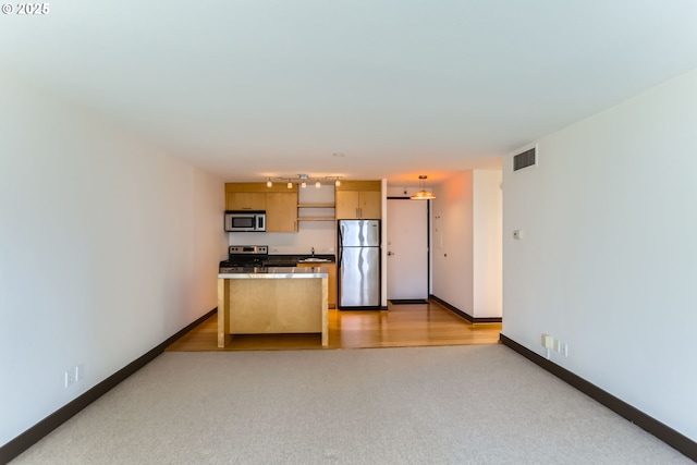 kitchen with baseboards, visible vents, stainless steel appliances, and a sink