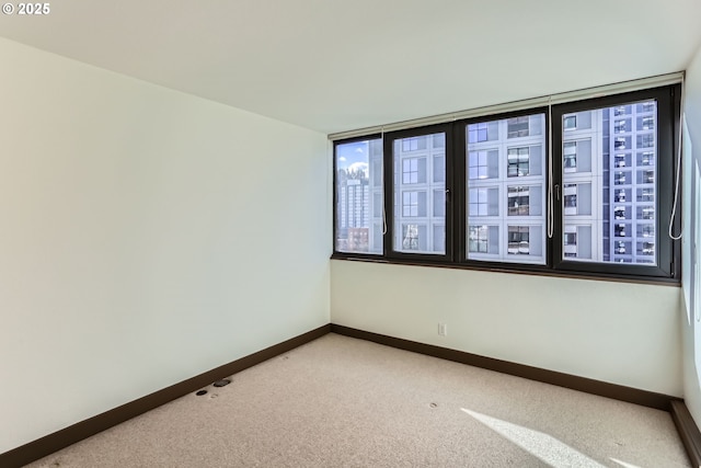 empty room with baseboards and light colored carpet