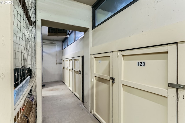 corridor with concrete floors and a high ceiling