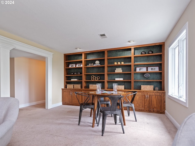 dining room with built in shelves and light colored carpet