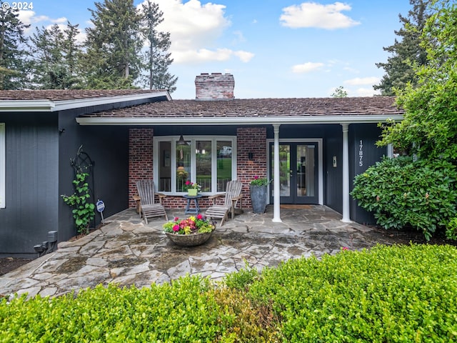 back of property featuring covered porch and french doors