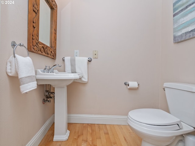 bathroom with hardwood / wood-style floors and toilet