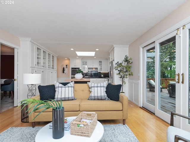 living room featuring a skylight and light wood-type flooring