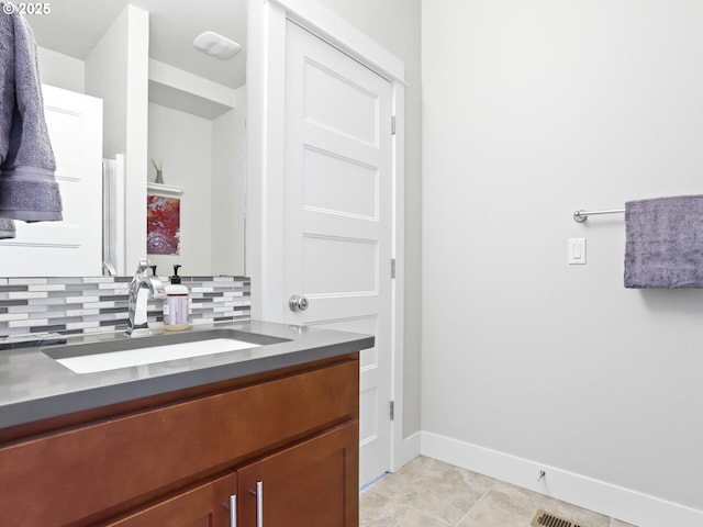 bathroom featuring tasteful backsplash, vanity, and tile patterned flooring