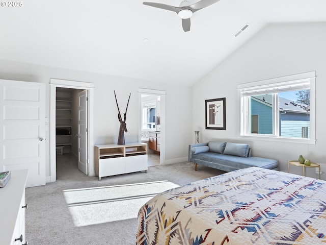 carpeted bedroom with a spacious closet, vaulted ceiling, ceiling fan, and ensuite bathroom