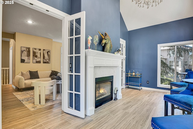 2672 SE Vista Way, Gresham, OR 97080 - living room featuring wood finished floors, a glass covered fireplace, high vaulted ceiling, and baseboards