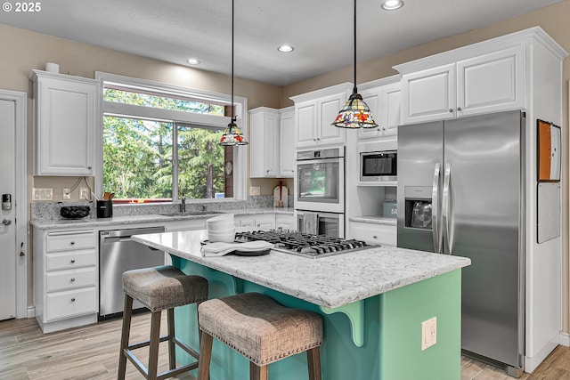 2672 SE Vista Way, Gresham, OR 97080 - kitchen with appliances with stainless steel finishes, a sink, white cabinets, a kitchen island, and recessed lighting