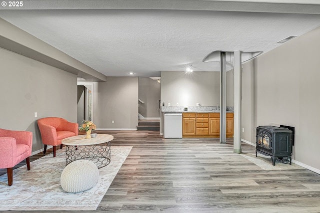 2672 SE Vista Way, Gresham, OR 97080 - living area with stairs, a wood stove, light wood finished floors, baseboards, and a textured ceiling