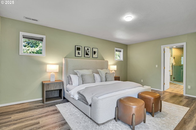 2672 SE Vista Way, Gresham, OR 97080 - bedroom featuring wood finished floors, baseboards, multiple windows, and ensuite bath