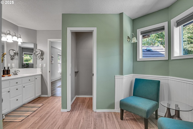 2672 SE Vista Way, Gresham, OR 97080 - full bathroom with vanity, wood finished floors, a textured ceiling, and wainscoting