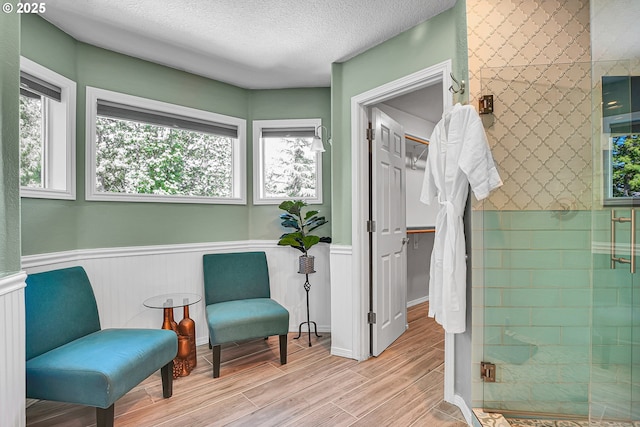 2672 SE Vista Way, Gresham, OR 97080 - living area featuring healthy amount of natural light, wainscoting, wood finished floors, and a textured ceiling