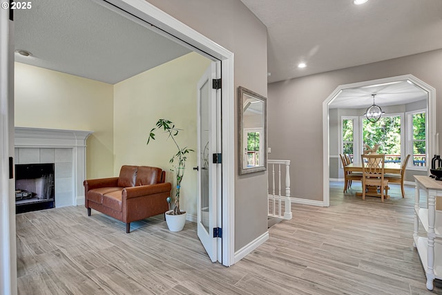 2672 SE Vista Way, Gresham, OR 97080 - sitting room with light wood finished floors, baseboards, recessed lighting, a tile fireplace, and arched walkways