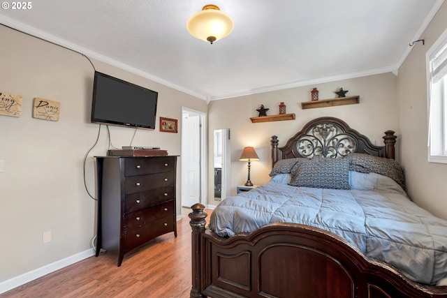 bedroom featuring crown molding, baseboards, and wood finished floors