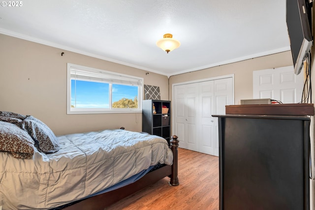 bedroom featuring ornamental molding, a closet, and light wood finished floors