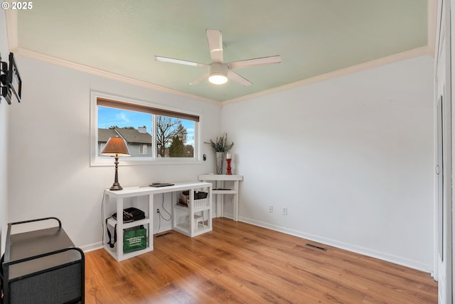 office space featuring light wood-style floors, crown molding, and a ceiling fan