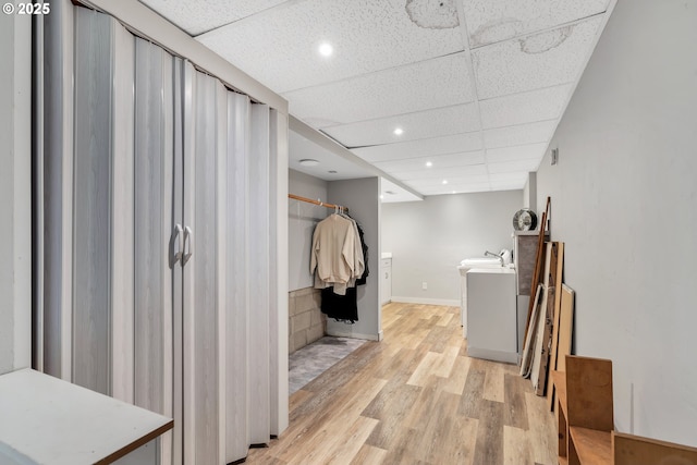 interior space featuring recessed lighting, wood finished floors, washer / dryer, a drop ceiling, and baseboards