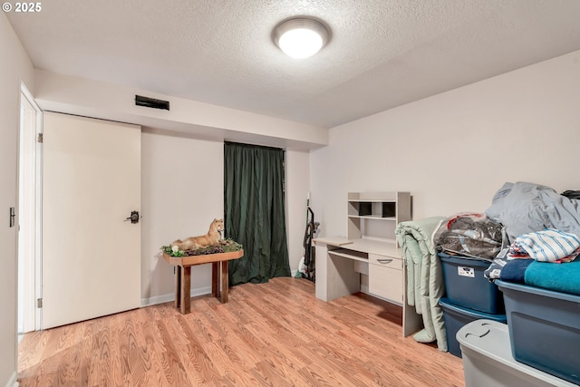 office with light wood-style floors and a textured ceiling