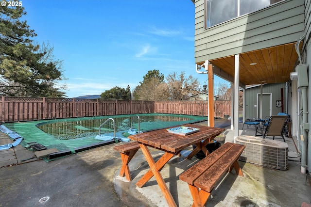 view of pool with outdoor dining area, a fenced backyard, central AC, a fenced in pool, and a patio area