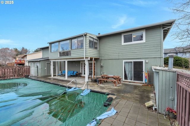 back of property with a patio, fence, and a fenced in pool