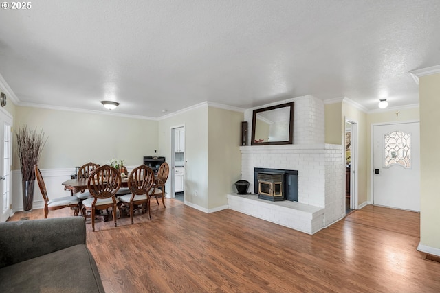 living room with crown molding, a textured ceiling, and wood finished floors